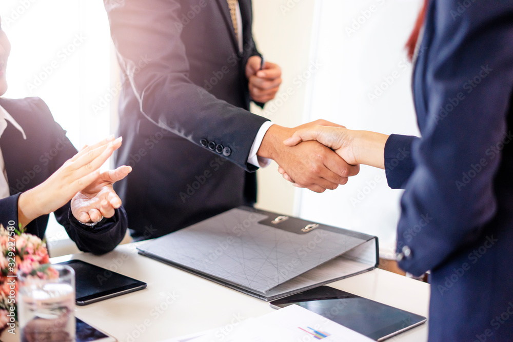 closeup of asian businessmen and business women shaking hands in partnership, working together in teamwork, planning strategies and decision making for the business or company to progress and succeed