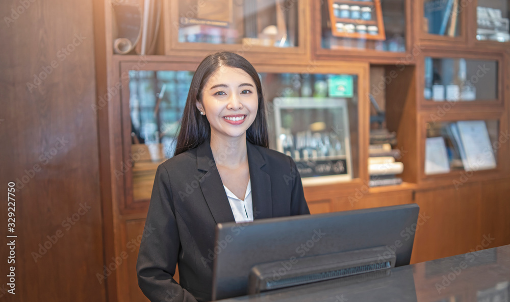 asian woman hotel receptionist standing behind a marble counter in ...