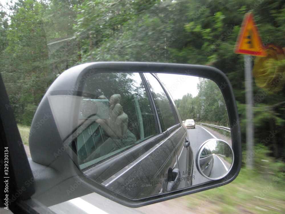 The car is reflected in the mirror of the driving car.