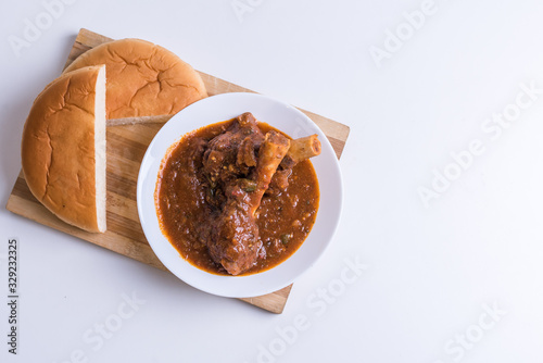 Hot and spicy Singapore's national dish the sup tulang made out of mutton bone marrow in a white bowl and white background photo