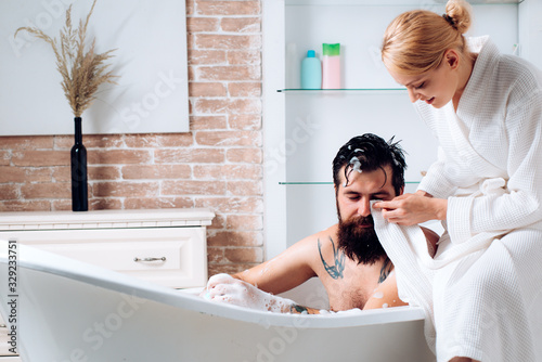 Romantic couple enjoying. Sensual couple of woman and man trimming with razor. Couple in bath grooming. Man and sensual woman. Couple of sensual girl and naked man trimming beard.