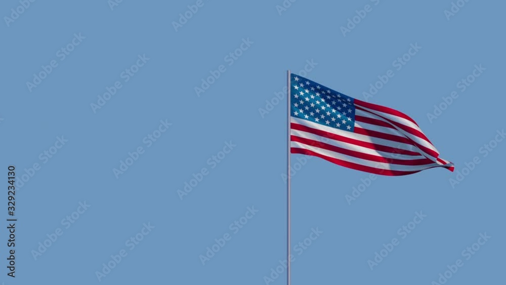 The American flag flutters in the wind against the sky The American flag flutters in the wind against the sky