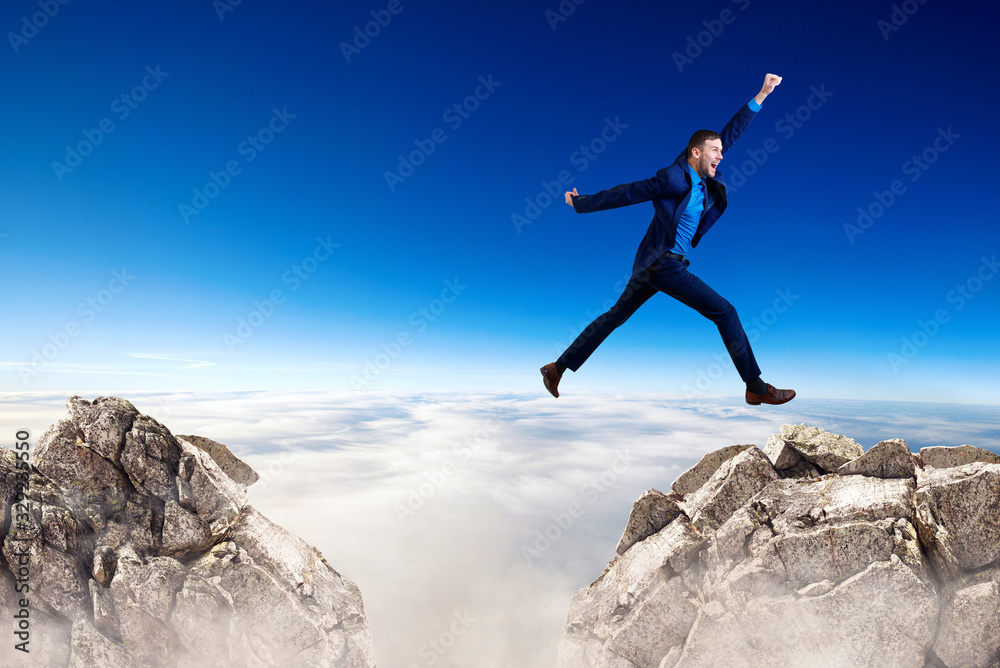 Young businessman flying through the gap among mountains. Young businessman flying through the gap among mountains.