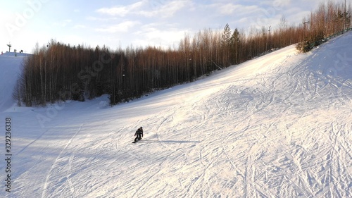 snowboarder slide down from the top of the mountain on a sunny winter day. areal view. The concept of snowboarding.