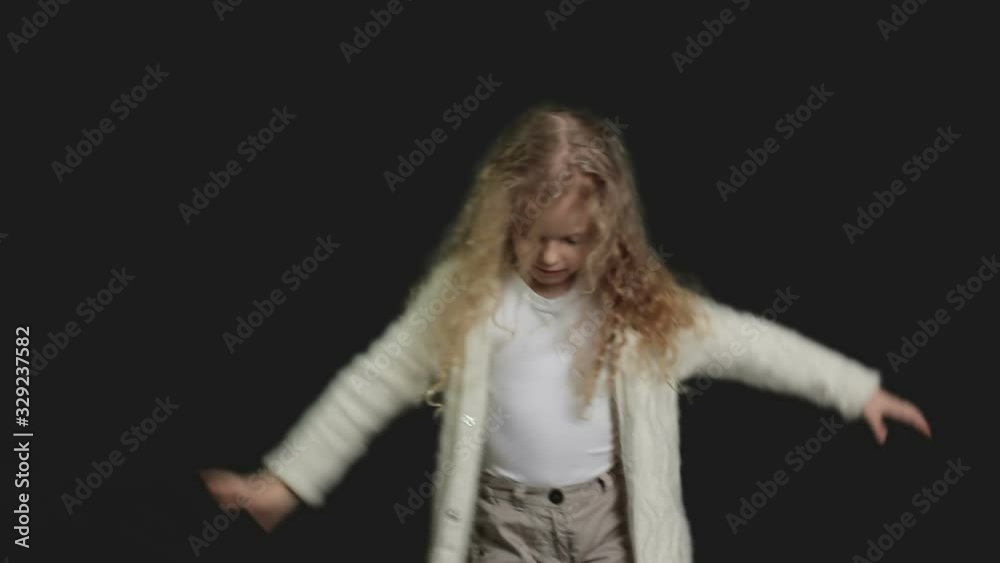 Little girl with blond curly hair, white shirt and white knitted jacket Little girl with blond curly hair, white shirt and white knitted jacket