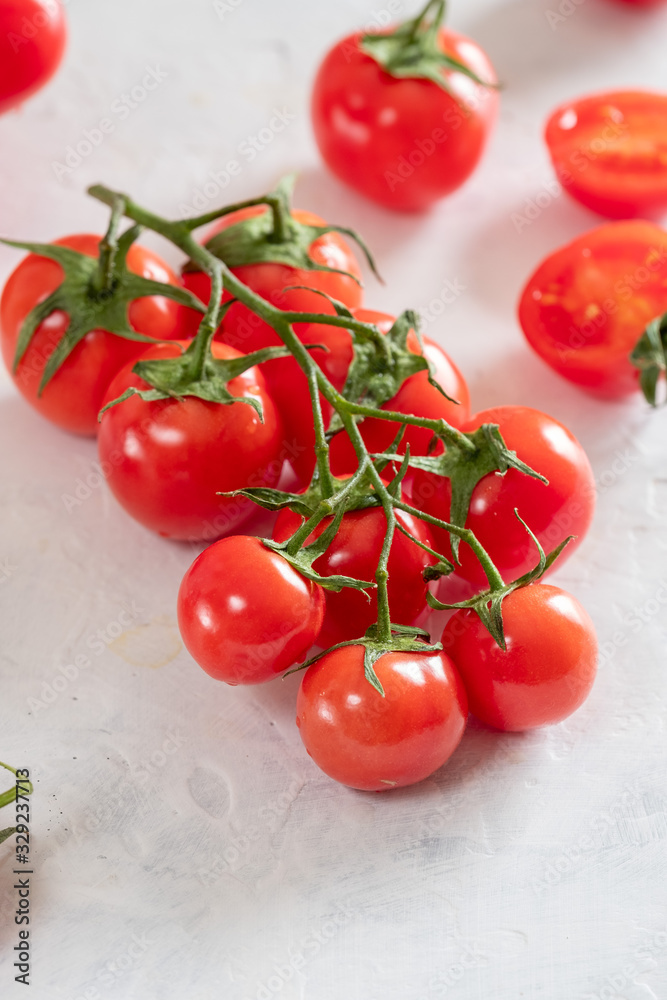 Fresh, bright and juicy cherry tomatoes on a white table Fresh, bright and juicy cherry tomatoes on a white table
