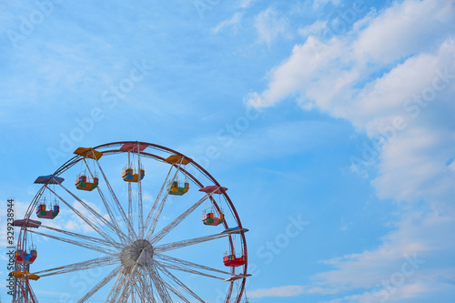 A  colorful Ferris wheel with beautiful clouds in the background
