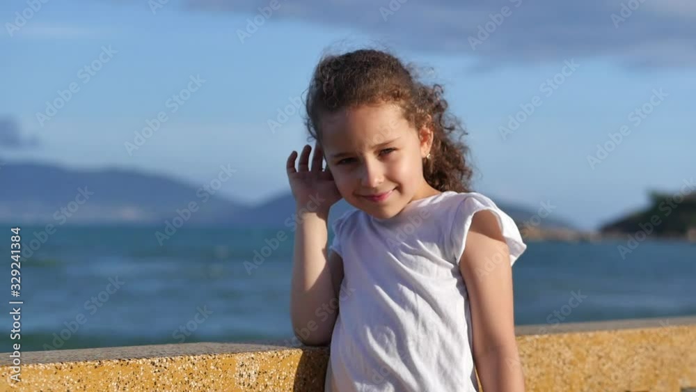 Portrait of a happy european child girl smiling cheerful enjoying warm summer vacation at seaside beach. Portrait of a happy european child girl smiling cheerful enjoying warm summer vacation at seaside beach.