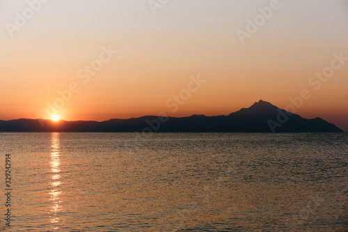 Wonderful sunrise view behind the mountains and next to the sea