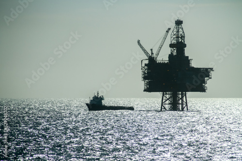 Silhouette of an Offshore Supply Vessel alongside oil platform in the North Sea.