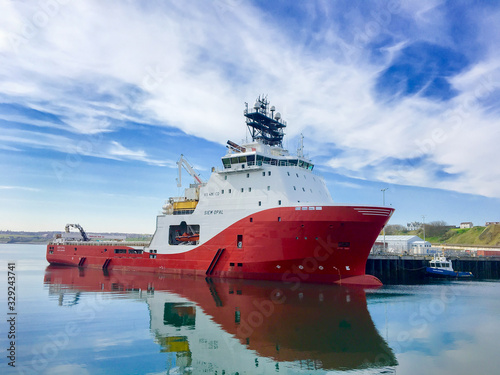 SCRABSTER, SCOTLAND - 2016 MAY 12. Offshore vessel AHTS Siem Opal moored inside harbour of Scrabster with blue skye and white clouds in the background. photo