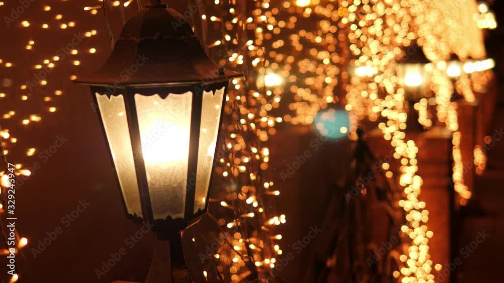 Festive blurred Golden lights from the street lamps on Christmas night on the street. Blurry Christmas lights festive background. Abstract christmas lights as background. Bokeh. Festive blurred Golden lights from the street lamps on Christmas night on the street. Blurry Christmas lights festive background. Abstract christmas lights as background. Bokeh.