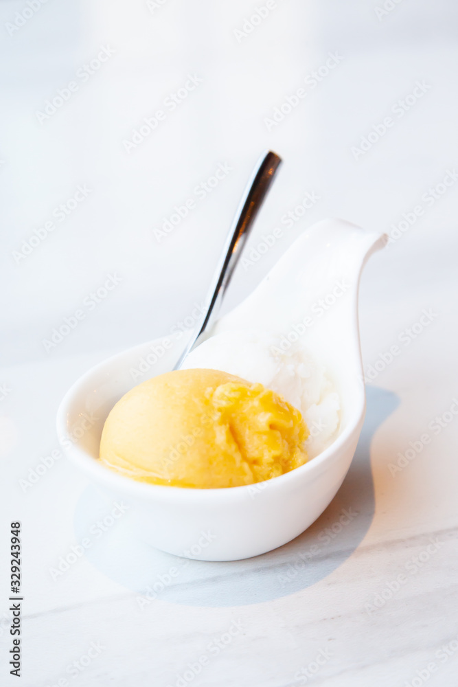 Mango and coconut ice cream served on mini white bowl Mango and coconut ice cream served on mini white bowl