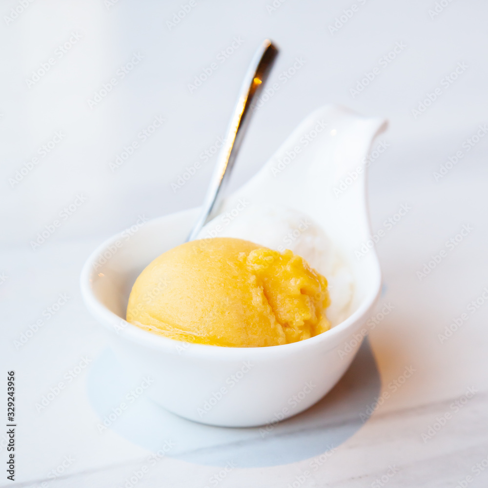 Mango and coconut ice cream served on mini white bowl Mango and coconut ice cream served on mini white bowl