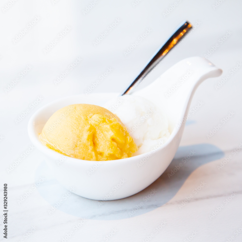 Mango and coconut ice cream served on mini white bowl Mango and coconut ice cream served on mini white bowl