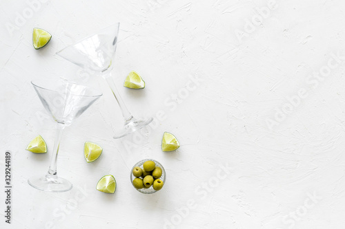 Cocktail concept. Martini glasses near olives and lemon on white background copy space