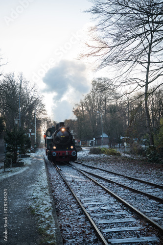 Dampflokomotive während der Fahrt an einem Bahnübergang