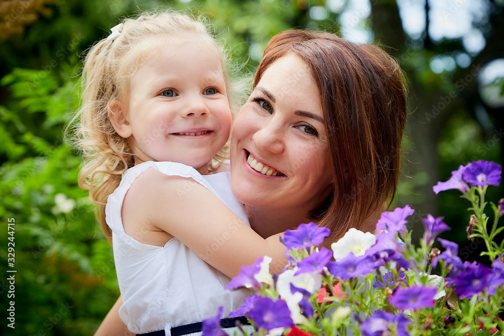 Happy mother and daughter resting and hugging in the park. Beauty nature scene with family outdoor lifestyle Happy mother and daughter resting and hugging in the park. Beauty nature scene with family outdoor lifestyle
