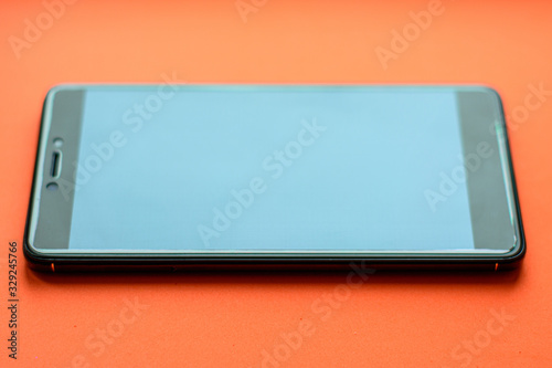 Smartphone, front and back side of smartphone with modern touch screen isolated on orange background. 2020