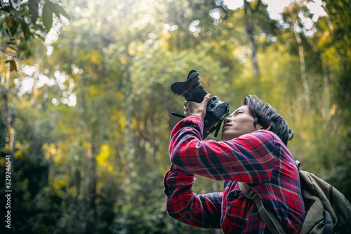 Man photographer holding camera taking photo nature in forest