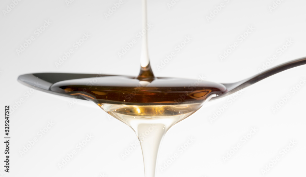 Natural Honey syrup on the spoon Natural Honey syrup on the spoon