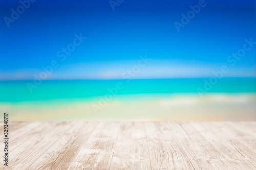 Empty wooden terrace on the beach with blurred water and sky. Close-up view with selective focus.