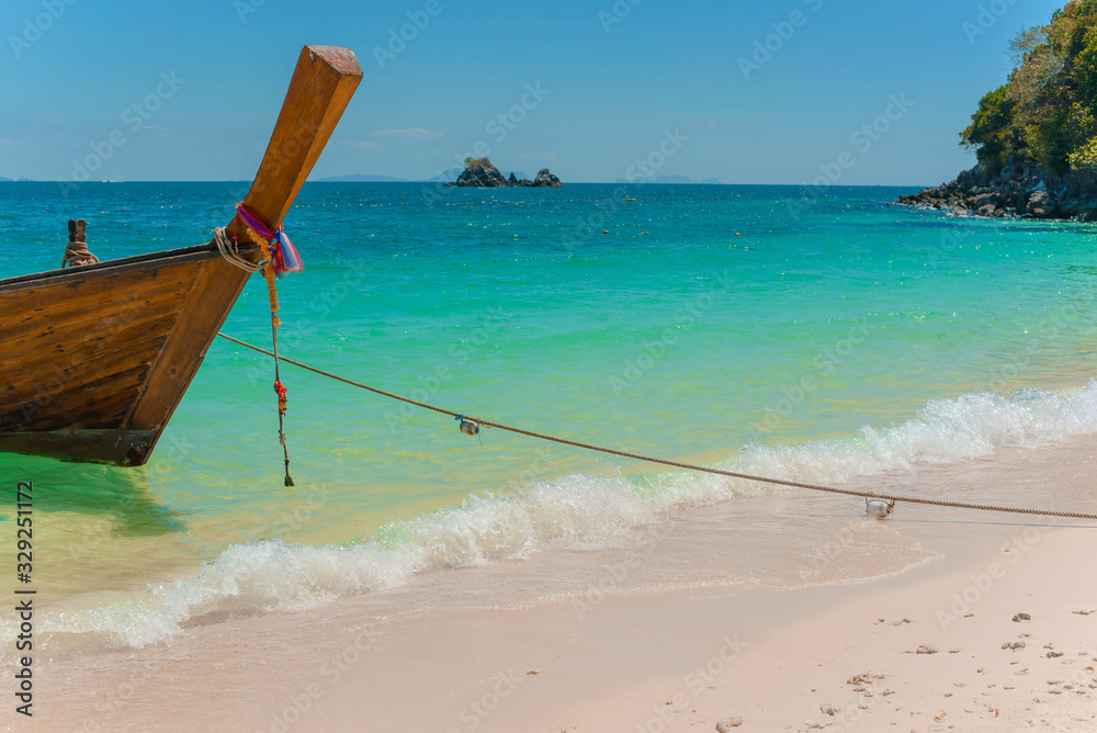 Traditional Thai longtail boat moored on exotic beach. Traditional Thai longtail boat moored on exotic beach.