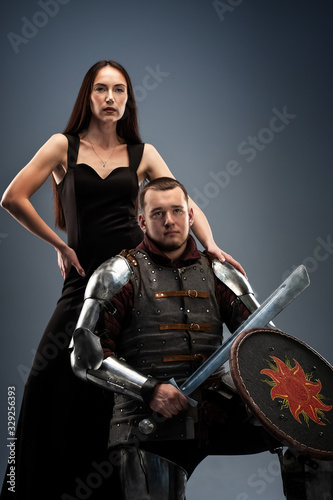 Beautiful girl in a black dress and knight in armor