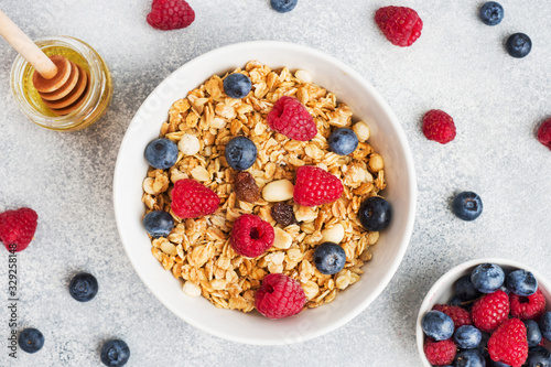 Healthy breakfast. Fresh granola, muesli with yogurt and berries on grey background. Copy space photo