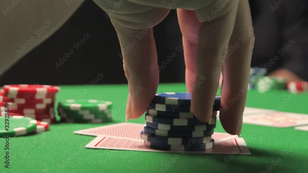 Playing poker in casino. Woman is fingering the chips in her hand Playing poker in casino. Woman is fingering the chips in her hand