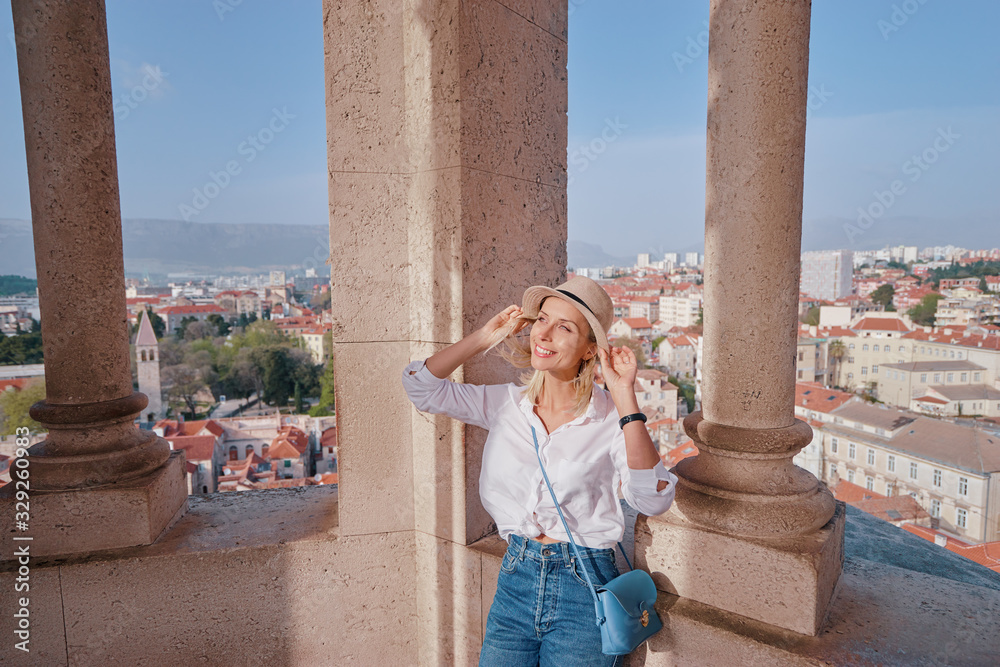 Traveling by Croatia. Young traveling woman enjoying old town Split view, red tiled roofs and ancient architecture in Diocletian tower.