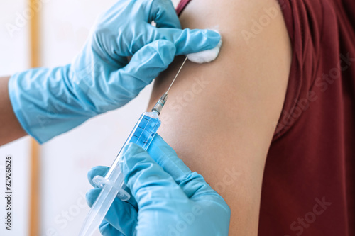Doctor making injection vaccination patient to prevent pandemic of the disease  flu or influenza virus in clinic