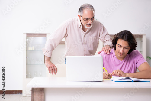 Old father helping his son in exam preparation