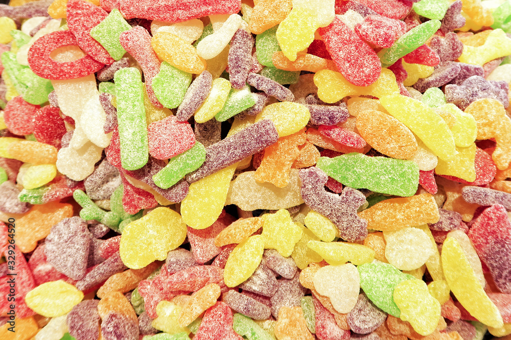 Flat top view of multicolored chewing marmalade. Texture of dessert marmalade with a sharp and sweet-sour taste. Jelly candies in bright red, yellow, green and orange colors. Flat top view of multicolored chewing marmalade. Texture of dessert marmalade with a sharp and sweet-sour taste. Jelly candies in bright red, yellow, green and orange colors.