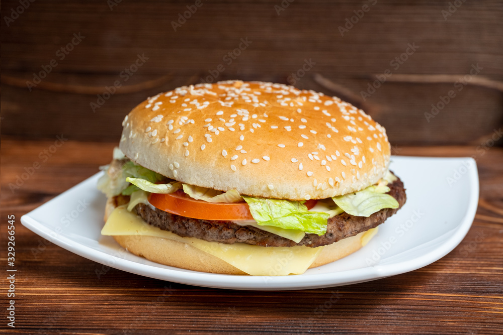 Burger on a plate and wooden background.