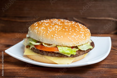 Burger on a plate and wooden background.