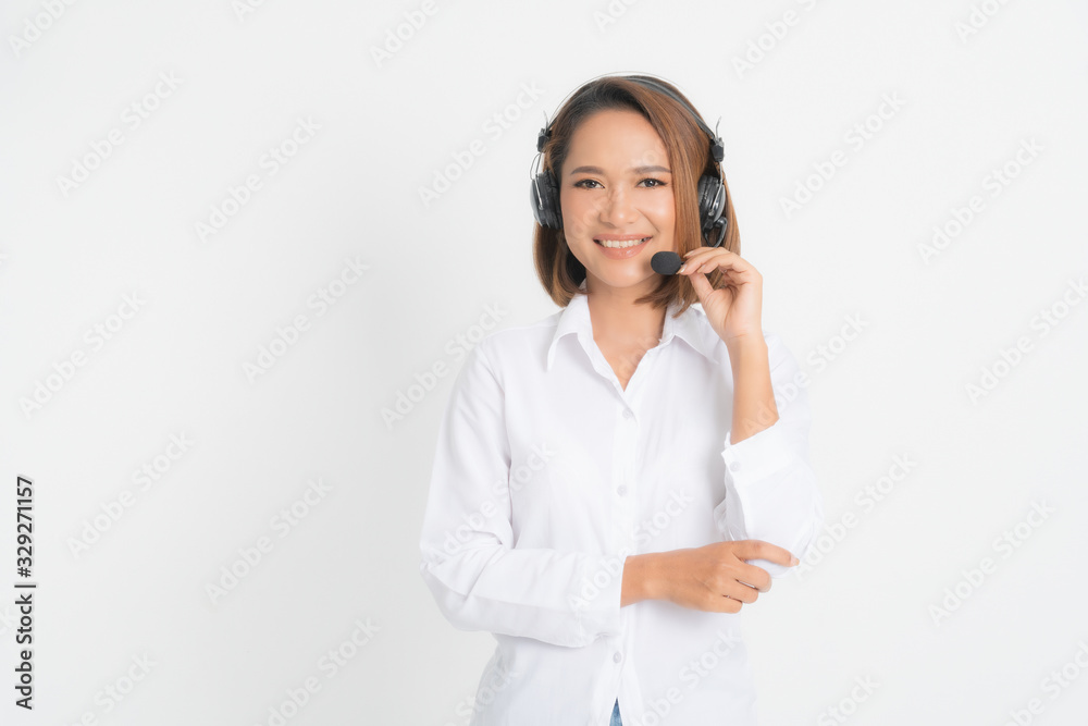 Portrait of happy smiling female customer support phone operator short hair, wearing a white shirt with headset standing one side holding the earphone isolated on white background.
