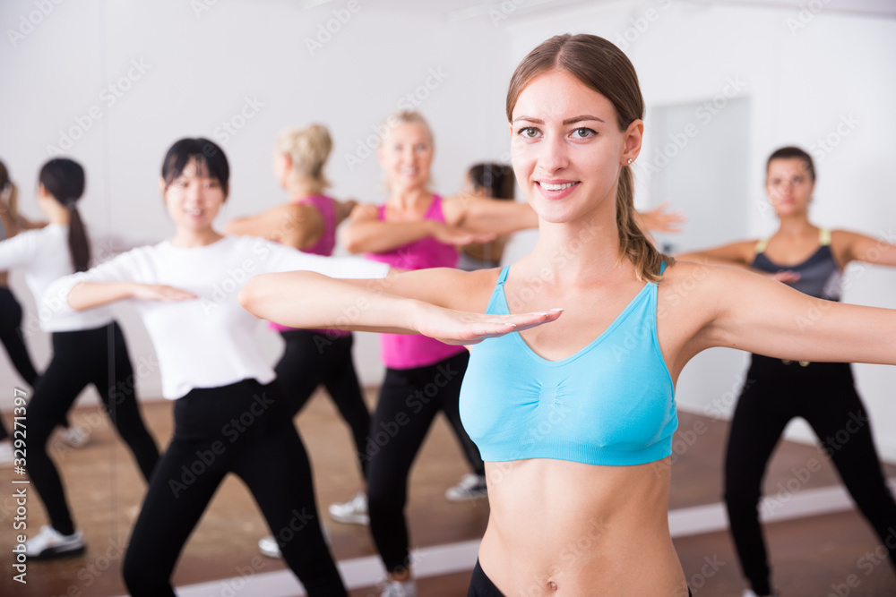 Group of active smiling people dancing together in dance studio