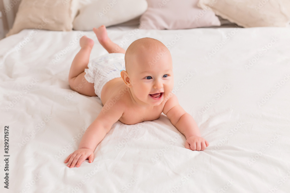 baby boy smiling and lying on a light bed at home baby boy smiling and lying on a light bed at home