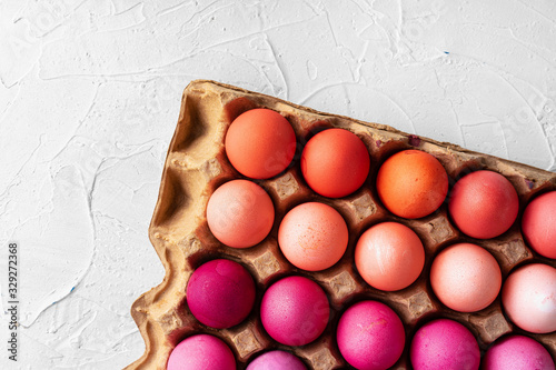 Several Easter eggs in different shades of pink in eggbox photo