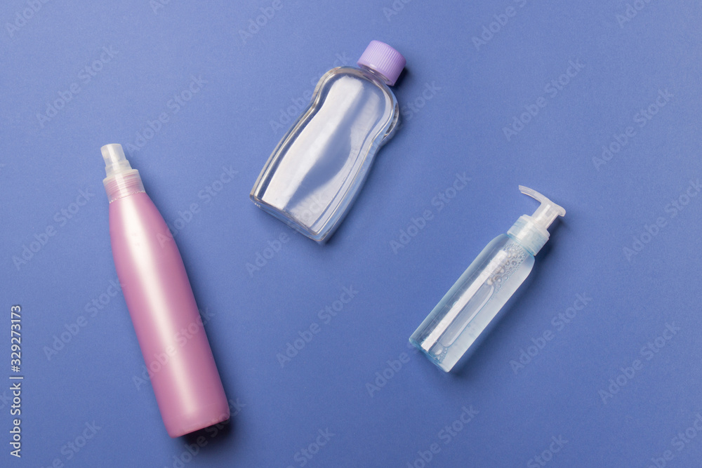 purple and blue cosmetic bottles on blue background purple and blue cosmetic bottles on blue background