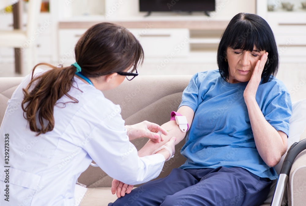 Obraz premium Doctor making injection to senior old woman