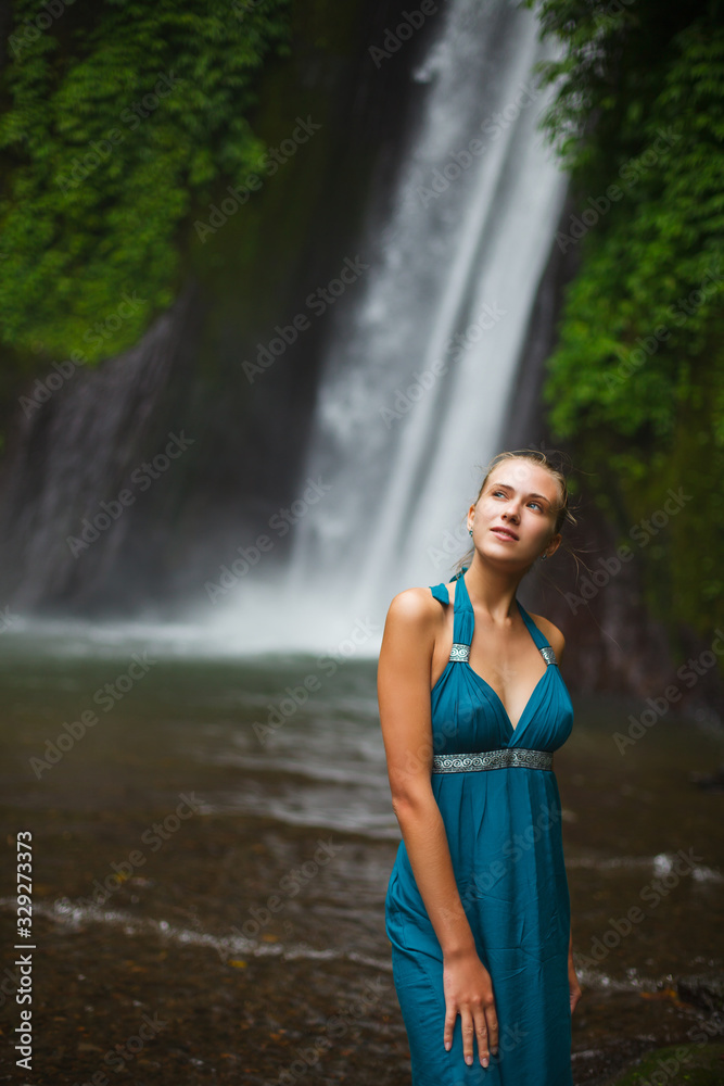 beautiful girl walks near a waterfall beautiful girl walks near a waterfall