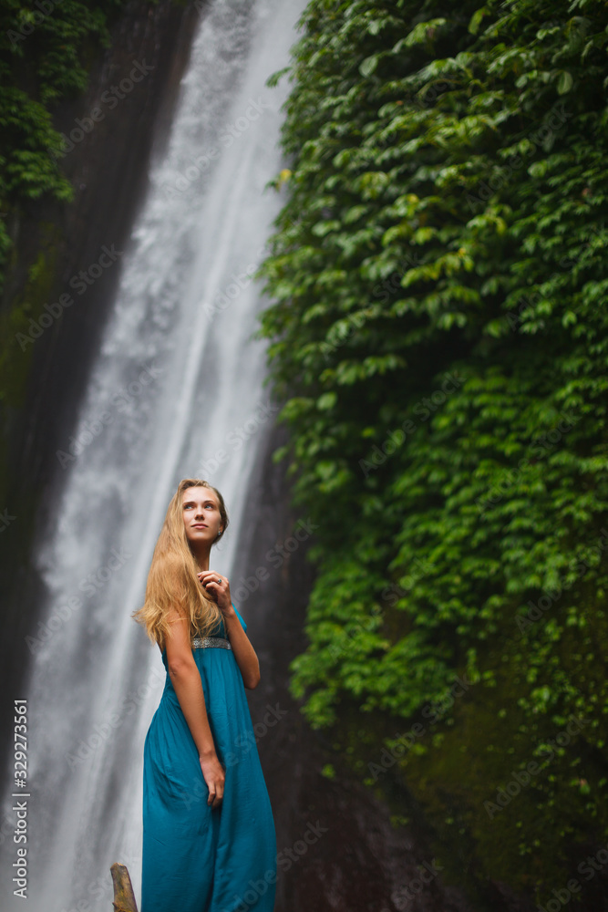 beautiful girl walks near a waterfall beautiful girl walks near a waterfall
