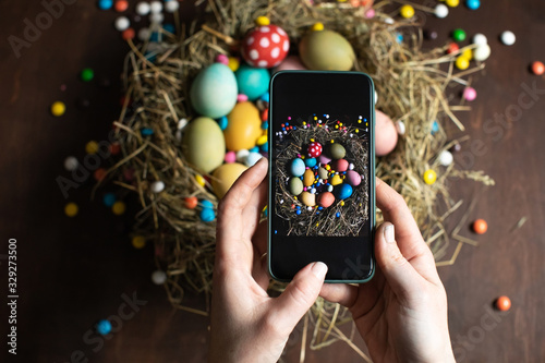 Canvas Print Woman making picture on mobile phone of  Easter eggs in nest