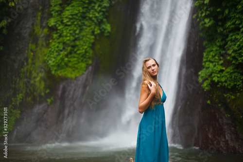 beautiful girl walks near a waterfall