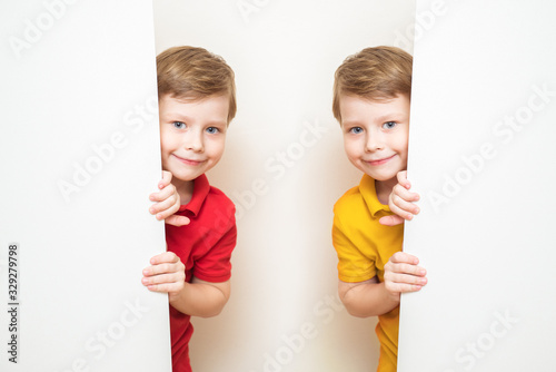 Twins child boys are showing blank signboard or copyspace for slogan or text on white background
