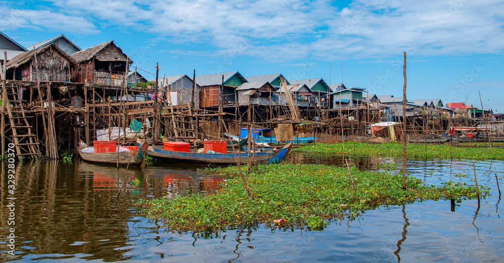 See Tonle Sap in Kambodscha: Panorama von Häusern im Wasser auf Stelzen mit grünen Wasserpflanzen