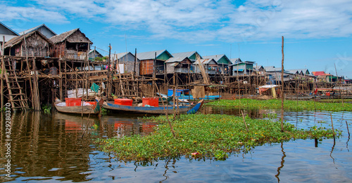 See Tonle Sap in Kambodscha: Panorama von Häusern im Wasser auf Stelzen mit grünen Wasserpflanzen