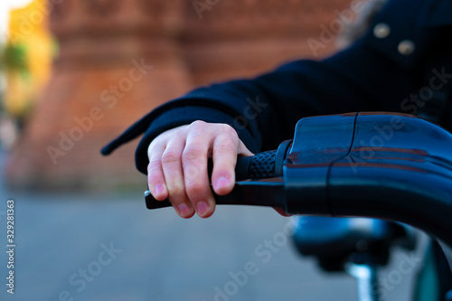 Hand taking the handlebars of a bicycle.